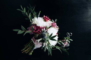 Koyu arkaplanda kırsal tarzda güzel bir gelin buketi.