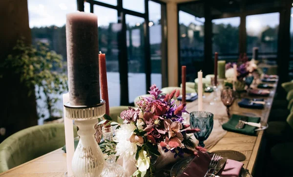 Taze çiçek ve mumlarla süslenmiş bir düğün masası.