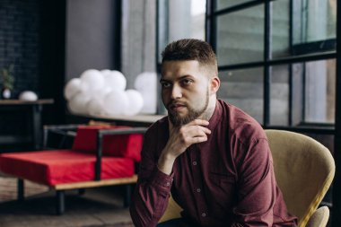 Bir kafede oturan genç adamın portresi.