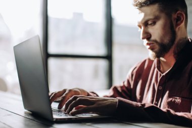 Serbest çalışan, evde dizüstü bilgisayarda çalışan bir adam..