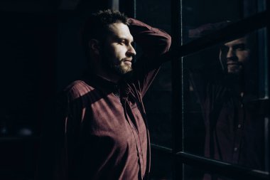 Pencerenin yanında sakallı genç bir adamın portresi. Vahşice