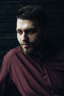 Boynunda dövmesi olan sakallı bir adamın vahşi portresi.