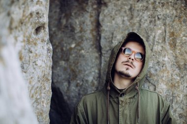 Kapüşonlu ve gözlüklü genç hippi.