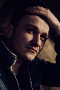 Genç adam doğada bir şeyler düşünüyor.