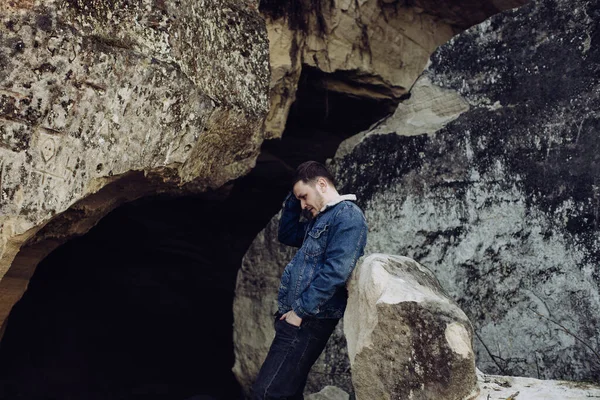 年轻寂寞的嬉皮士坐在岩石上 — 图库照片