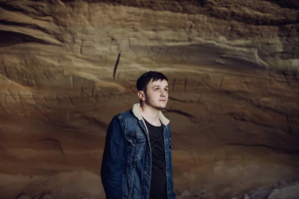 Sad Young Man Denim Jacket Stands Cave Mountains — Stock Photo, Image