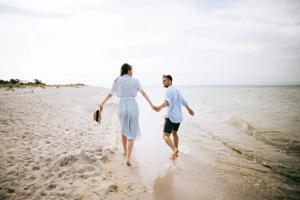 young happy couple walking on sea beach