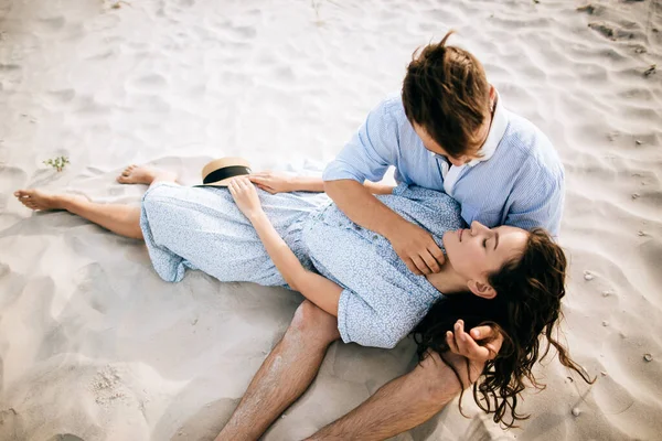 年轻夫妇躺在海滩上亲吻拥抱 — 图库照片