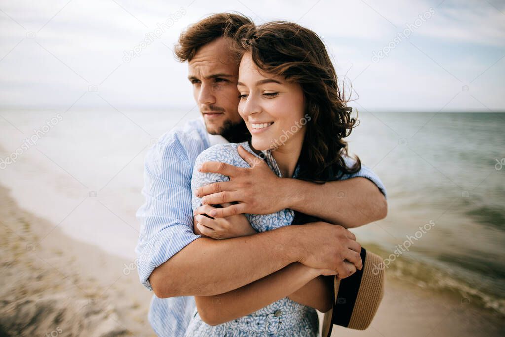 Young man hugging happy woman. Happy couple relaxing at sea in their honeymoon