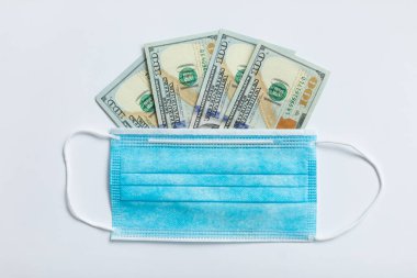 Para, dolar banknotları ve koruyucu bir tıbbi maske. ABD 'deki koronavirüs salgını sırasında ekonomik ve sosyal sorunlar kavramı