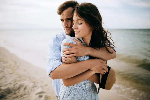 快乐的年轻夫妇在海滩上拥抱和亲吻 蜜月与爱情的概念 — 图库照片