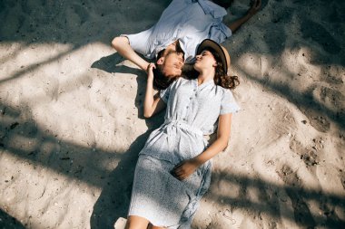 Kumsalda uzanan ve öpüşen genç bir çift. Tatil ve eğlence konsepti