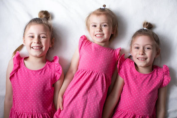 Trois Petites Filles Robes Roses Sont Allongées Sur Lit Souriantes — Photo
