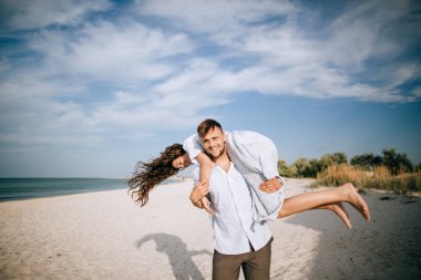 Kumsalda dinlenen mutlu genç çift. Yaz tatili