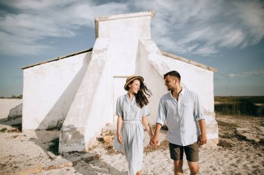 Mutlu adam ve kadın yaz tatillerinde sahilde yürüyorlar.