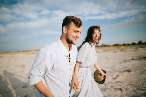 Deniz kıyısında yürüyen mutlu bir çift. Deniz yolculuğu ve yaz tatili