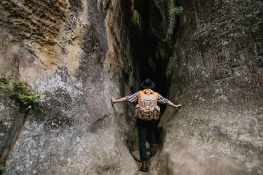 Sırt çantalı ve turuncu ceketli genç bir hippi dağ mağarasına girer. Seyahat kavramı