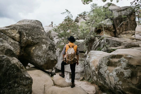 Seorang Pria Dengan Jaket Oranye Dan Topi Berdiri Atas Batu — Stok Foto