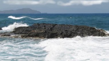 Dalgalar deniz ortasında Rock güzel beyaz dalgalar ile derin mavi su yüzeyi