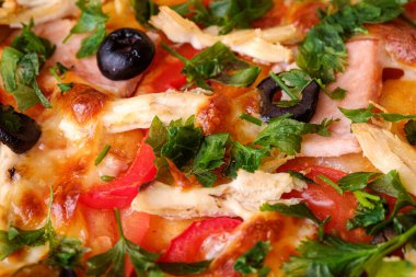 Tavuk eti, jambon, domates, mozzarella peyniri, siyah zeytin ve maydanozlu taze ev yapımı pizza.