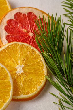 Yılbaşı için yaratıcı bir Noel yemeği, kurutulmuş greyfurt, köknar ağacı makrosu dallı portakal ve limon, açı açısı, beyaz arka plan, seçici odaklı.