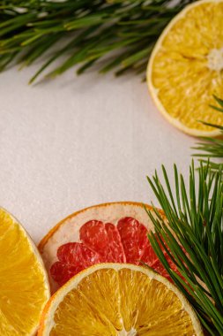 Yılbaşı için yaratıcı bir Noel yemeği, kurutulmuş greyfurt, köknar ağacı makrosu dallı portakal ve limon, açı açısı, beyaz arka plan, seçici odaklı.