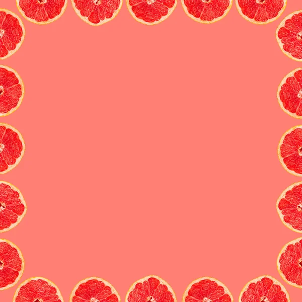 Grapefruit tropical frame texture, creative flat lay, fruit slices on pink background, copy space
