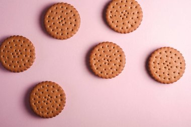 Kremalı çikolatalı sandviç, marketten tatlı yiyecekler, pembe pastel arka plan, üst manzara.