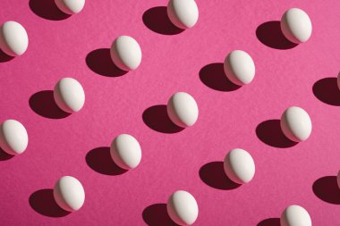 Pembe mor renkte beyaz yumurta deseni sade arka plan, açı görünümü, mutlu Paskalya günleri.