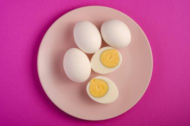 Pembe tabakta soyulmuş yumurta ve pembe renkler sade arka plan, üst manzara, mutlu Paskalya günleri.