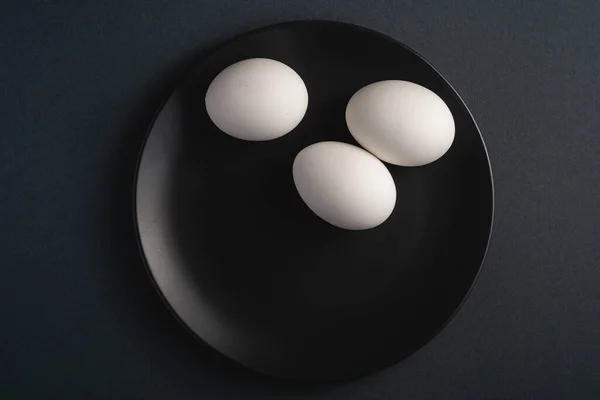 Huevos Blancos Plato Negro Sobre Fondo Oscuro Moody Simple Mínimo —  Fotos de Stock