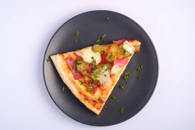 Pepperoni, salam, erimiş mozzarella peyniri, turşu ve dereotlu pizza dilimi beyaz arka planda, üst görünüm kopyalama alanı