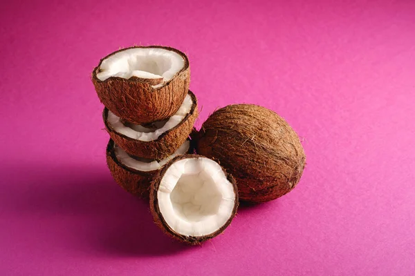 ピンク紫色の無地の背景に積み重ねられたココナッツの果物 抽象的な食べ物熱帯の概念 角度ビューのコピースペース — ストック写真
