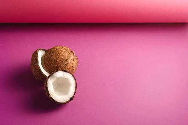 鮮やかなピンクの紫色の折り畳まれた紙の背景にココナッツフルーツ 抽象的な食品熱帯の概念 コピースペース角ビュー — ストック写真