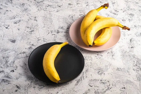 Bananfrukter Rosa Och Svarta Plattor Vit Strukturerad Bakgrund Vinkel Visa — Stockfoto