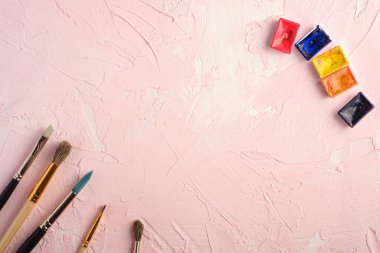 Boya fırçaları, ressam araçları desenli pembe arkaplan, üst görünüm, kopyalama alanı