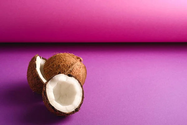紫色の紫色の折り畳まれた紙の背景にココナッツフルーツ 抽象的な食品トロピカルコンセプト 角度表示コピースペース — ストック写真