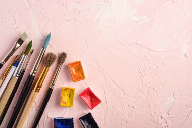 Boya fırçaları, ressam araçları desenli pembe arkaplan, üst görünüm, kopyalama alanı