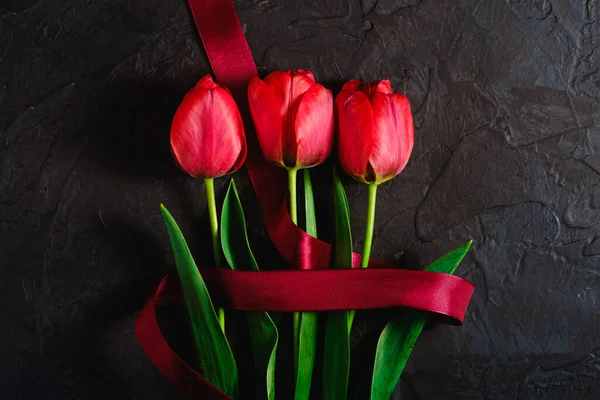 Red Bunch Tulip Flowers Red Ribbon Textured Black Background Top — Stock Photo, Image