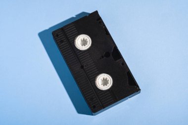 VHS biçimi plastik video kaset, analog retro teknoloji manyetik depolama bandı minimum pastel mavi arka planda