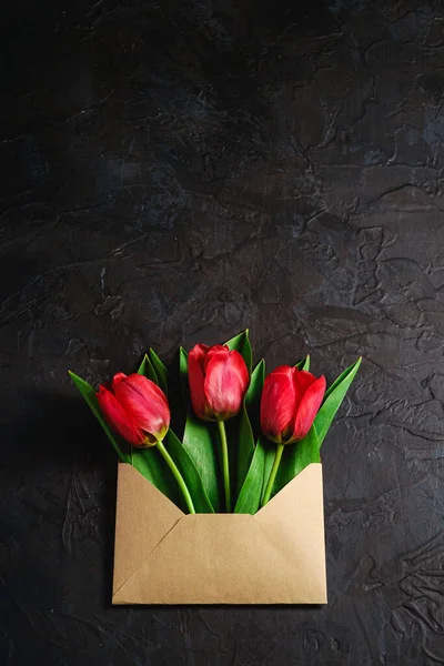 Bunch Red Tulip Flowers Paper Envelope Textured Dark Black Background — Stock Photo, Image