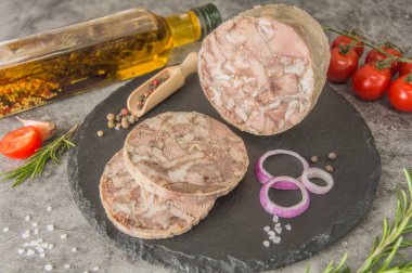 Kafa peyniri, siyah tahtada kesilmiş ezilmiş bir et parçasıdır. Yakın plan, baharatlı, biberiyeli, domatesli. Tabak menüde.