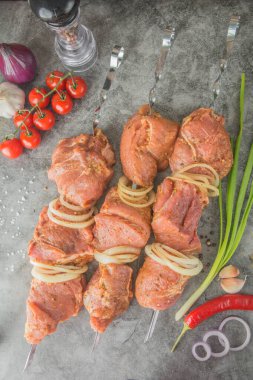 Şişe üzerinde çiğ et parçaları - kebap. Baharatlar, biberler, domatesler, üst manzara..