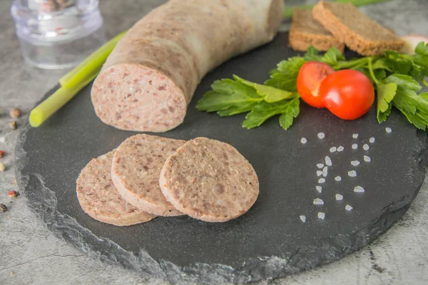 Dilimlenmiş ciğer ezmesi, siyah tahtada otlar ve baharatlarla. Yakın plan..