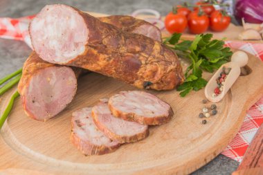 Kıymalı sosis, ahşap bir tahtanın üzerinde baharat ve otlarla küçük parçalara bölünmüş. Yakın plan.