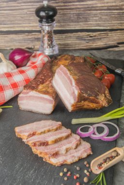 Pastırmalı tütsülenmiş et, siyah tahtada baharatla dilimlenmiş. Et yemeği - Pidcherevyna yan görünümü