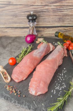 Çiğ domuz filetosu. Doku, lif ve filmli kesilmemiş et dilimi, biberiyeli ve baharatlı siyah yazı tahtası değil. yan görünüm