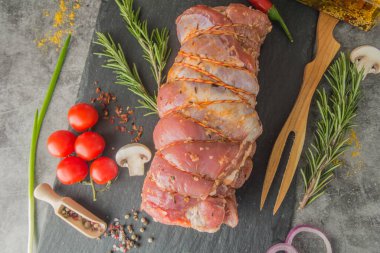 Siyah tahtada sicimle kaplı köfte, baharatlar ve et çatalı, üst manzara.