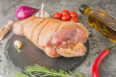 Salamura edilmiş çiğ domuz budu, sicimle kaplı, siyah tahtada baharatlar, yakın plan.