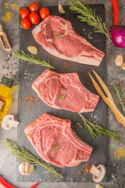 Három Nyers Steak Csonttal Fekete Palán Fűszerekkel Éttermi Konyhában Felülnézetből — Stock Fotó